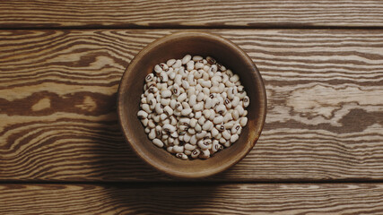 TOP VIEW: Dried white beans in a wooden dish