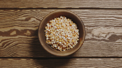 TOP VIEW: Dried yellow peas in a wooden dish