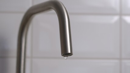 Dripping steel faucet on kitchen