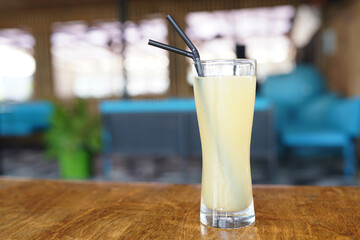 Fresh summer ice cold lemon cocktail on wooden table outside