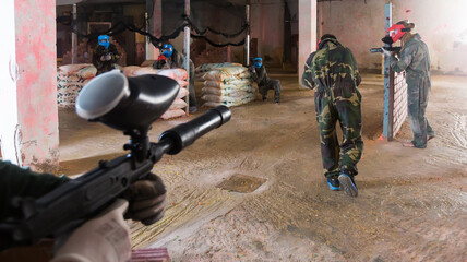 Fototapeta premium Player is targeting in foe in battlefield in paintball club.