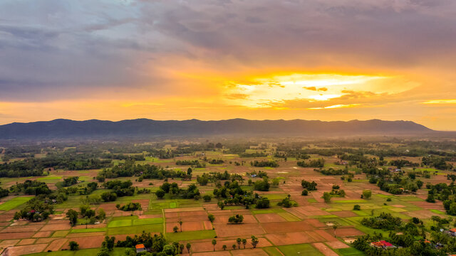 A Top Down Aerial View Of A Small Country Town With Traditional Houses In Sunset Besides Mountain In Cambodia.