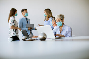 Group of business people have a meeting and working in office and wear masks as protection from corona virus
