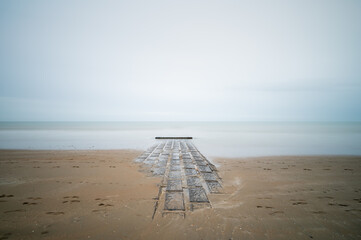 A breakwater enters a misty sea in the North Sea.