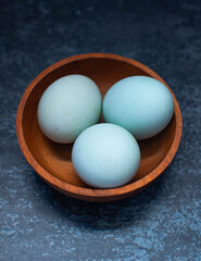 salted eggs on a wooden bowl. dark background