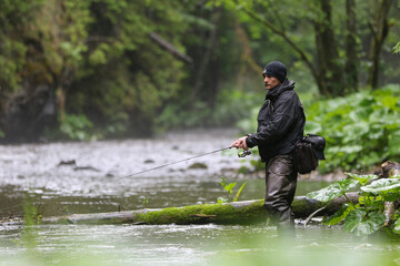 A fisherman walking for wild river and a breathtaking scene in the forest with colourful...