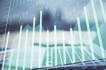Stock market graph on background with desk and personal computer. Multi exposure. Concept of financial analysis.
