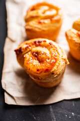 Fresh sweet bun with orange jam on the rustic wooden background. Selective focus.

