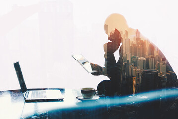 Double exposure silhouette of man skilled managing director is analyzing activities of the company by using touch pad and net-book. Thoughtful economist is reading news in network via digital tablet - obrazy, fototapety, plakaty