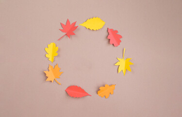 Autumn composition. Frame is made of paper autumn leaves on a beige background. Greeting card, autumn season, thanksgiving. Minimum concept. Top view,  flat lay, copy space