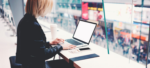 Female successful businesswoman is using for distance work laptop computer with empty copy screen for your advertising text message. Hipster girl is searching information on web page via net-book