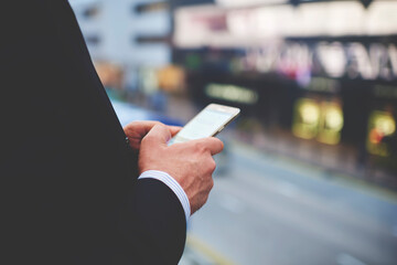 Closeup of man`s hands is holding cellphone with empty copy space screen for your advertising text message or promotional content. Closely of businessman search information in network via smart phone