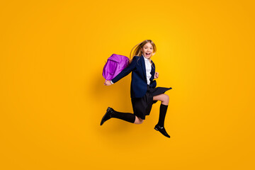 Fototapeta na wymiar Full length body size view of nice small little cheerful glad funky girlish energetic girl learner jumping having fun after classes isolated bright vivid shine vibrant yellow color background