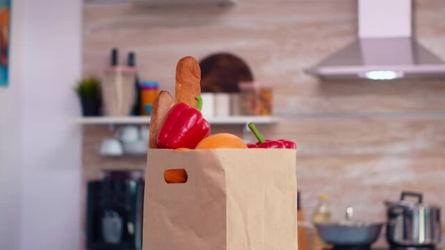 Fresh vegetables in paperbag on kitchen table top. Organic lifestyle healthy young purchase from supermaket, fresh vegetables groceries shopping bag