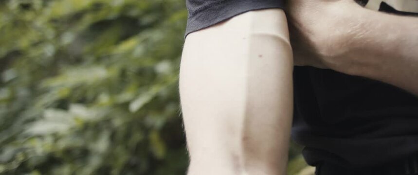 Climber flexing his biceps muscle on strong hand after rock climb outdoors lifestyle sport in nature unrecognizable close up