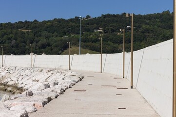 Lampposts on the pier at the harbor with tetrapod breakwaters (Pesaro, Italy, Europe)