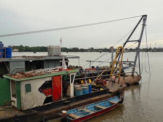Fototapeta na wymiar Dredger ,Dredging mud in the river for large boats to pass through.