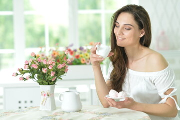 Young beautiful woman holding white cup at home