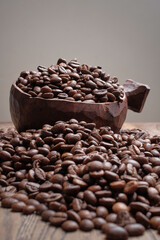 Coffee beans in bowl on wooden background. Selective focus
