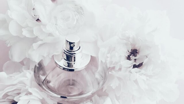 White perfume bottle with peony flowers, chic fragrance scent as luxury cosmetic, fashion and beauty product background, stock footage