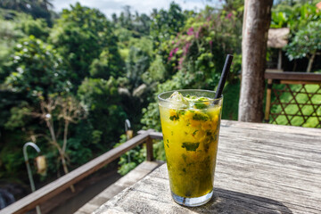 Mango and basil smash in a glass on the side of the table at a jungle cafe in Ubud, Gianyar, Bali, Indonesia.
