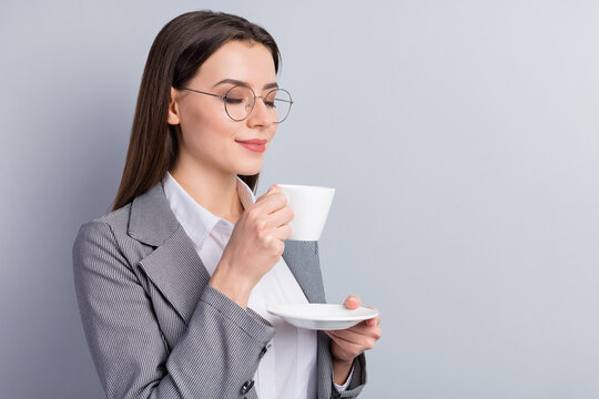 Closeup photo of attractive business lady manager hold white porcelain cup plate drink hot coffee enjoy nice smell eyes closed wear specs shirt plaid blazer isolated grey color background