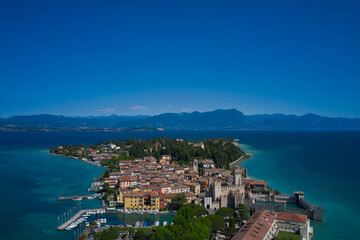 Sirmione, Lake Garda, Italy. Panoramic aerial view of the historic city of Sirmione. In the background mountains, blue sky