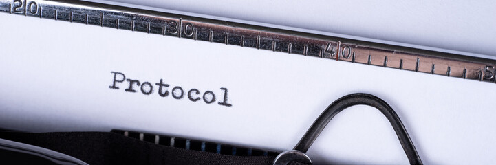The word Protocol written on an old typewriter. Panoramic image