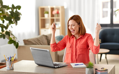 remote job, technology and people concept - happy smiling young woman with laptop computer working at home office and celebrating success