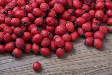 Hawthorn berries on a wooden table, top view, macro.