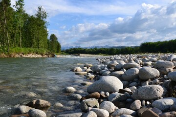 Fototapeta na wymiar Huge stones on the river bank. View of Bialka mountain river running through southern Poland. It is a tributary of the Dunajec River. Bialka river near Bialka Tatrzanska village, Poland, Europe