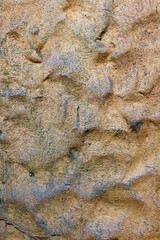 Rough surface of granite stone in golden shades of yellow