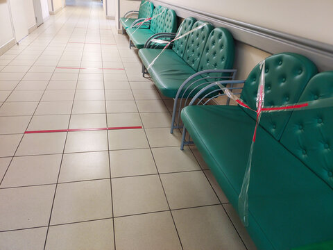 Sofas stand in front of bounding tape. Concept of new social rules after pandemic. Social distancing
