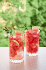 Summer refreshing drink with ice, slices of watermelon, lemon, rosemary,