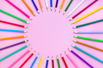 Colorful pencils on pink background, mockup, round layout, flat lay, top view, copy space