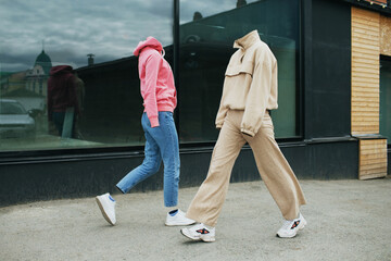 Empty woman clothes walk on street wearing hoody, jeans trousers, sneakers and colorful trainers
