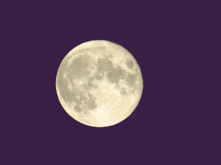 Genova, Italy - 07/07/2020: An amazing photography of the full moon over the city of Genova by night with a great clear and blue sky in the background and some stars.