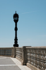 Fototapeta na wymiar Street lamp post. View of the promenade with white balusters and old street lamp. Beautiful seascape, view from stone balustrade on sunny summer day