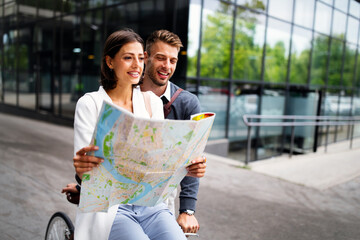 Holidays, dating and tourism concept. Smiling couple in love with map in the city
