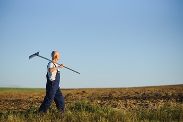 a farmer works with a rake