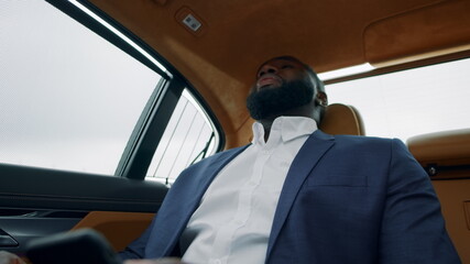 African businessman getting bad news on phone. Depressred man at luxury car