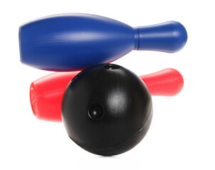 Black bowling ball striking colorful pins, skittles in air isolated on white background