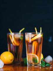Two glasses of summer ice tea with lemon and mint. Refreshing citrus drink