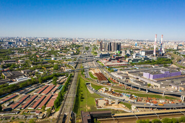 Fototapeta premium Power plant pipes and cooling towers in Moscow from above, automobile traffic and the old Ugreshskaya railway station in the Moscow industrial zone near the automobile ring highway.