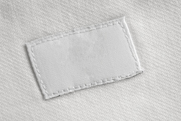 White blank laundry care clothes label on cotton shirt background