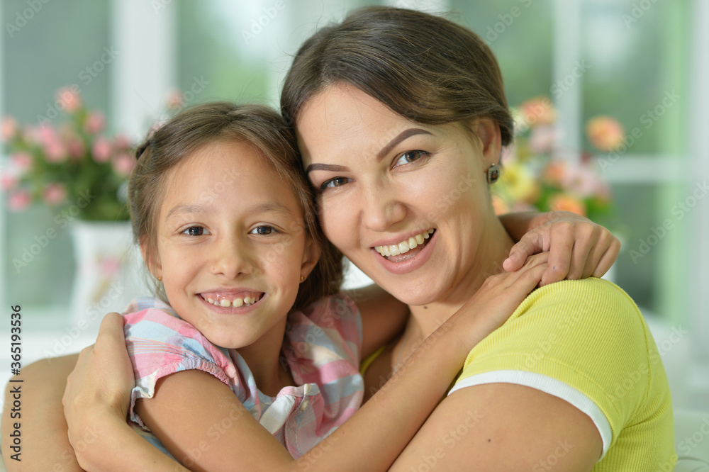 Poster Portrait of a charming little girl hugging with mom at home