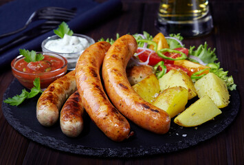 Beer cuisine: Fried sausages, baked potato, fresh vegetable salad, tomato sauce and tartar sauce.