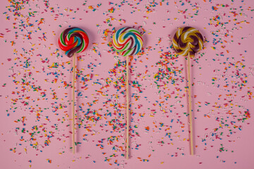 three lollipops on pink background stock photo