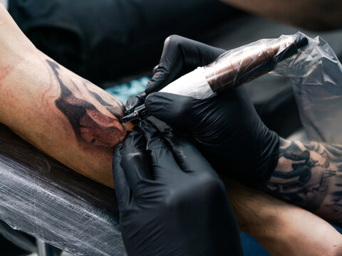Cropped Image Of Artist Making Tattoo On Man Hand