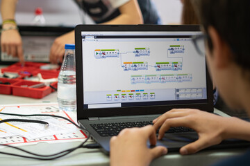 Niño programando un robot a través de un ordenador computadora en una clase de robótica